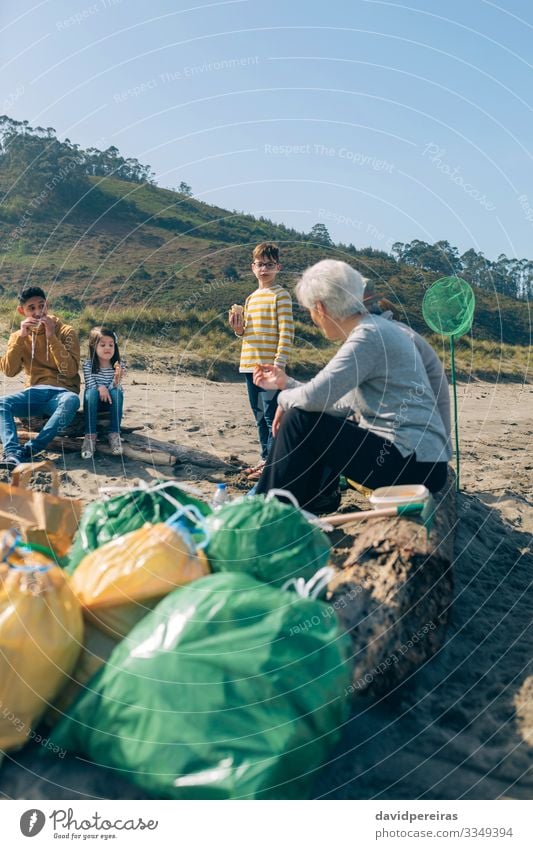 Volunteers resting after cleaning the beach Eating Drinking Coffee Beach Ocean Child To talk Human being Boy (child) Woman Adults Man Family & Relations Group