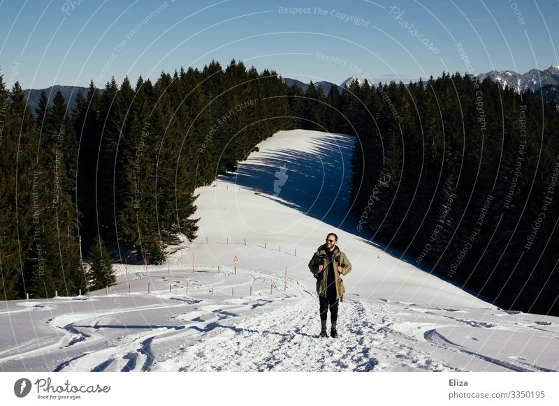 A man hiking in the mountains in winter with lots of snow Winter Hiking Snowscape Man slope Blue sky sunshine Mountain Nature Trip Bavaria Beautiful weather