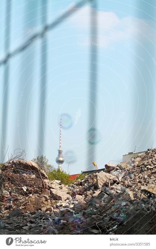 Television tower in Berlin, behind a construction site with fence, under a blue, cloudless sky in summer, photographed during a holiday trip in the capital.