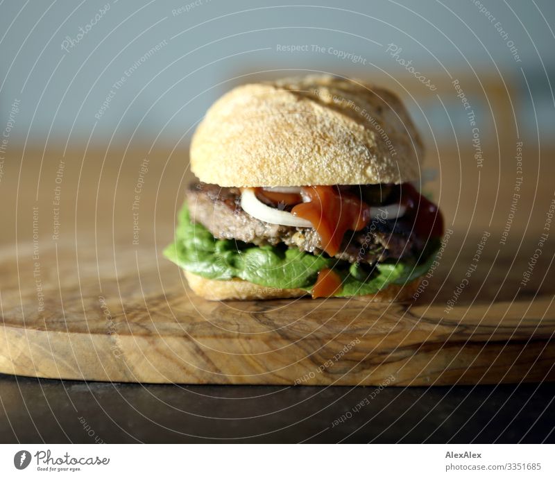 Hamburger sandwich with bread roll Food Meat Lettuce Salad Dough Baked goods Roll Sandwich Onion Minced meat beef Wooden board Chopping board Salad leaf Lunch