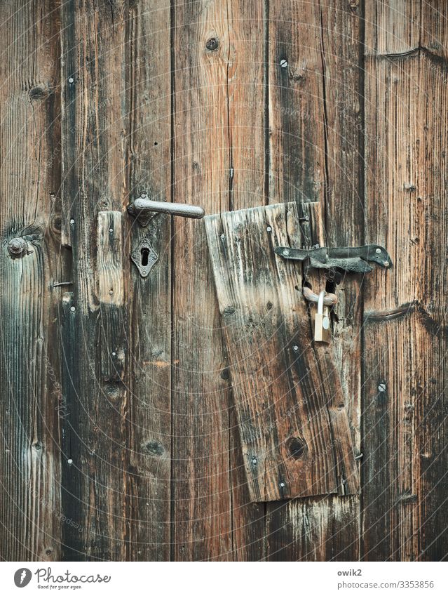 Board to Door Door handle Wooden board Metal Old Protection Safety Past Padlock Keyhole Texture of wood Wood grain Colour photo Subdued colour Exterior shot