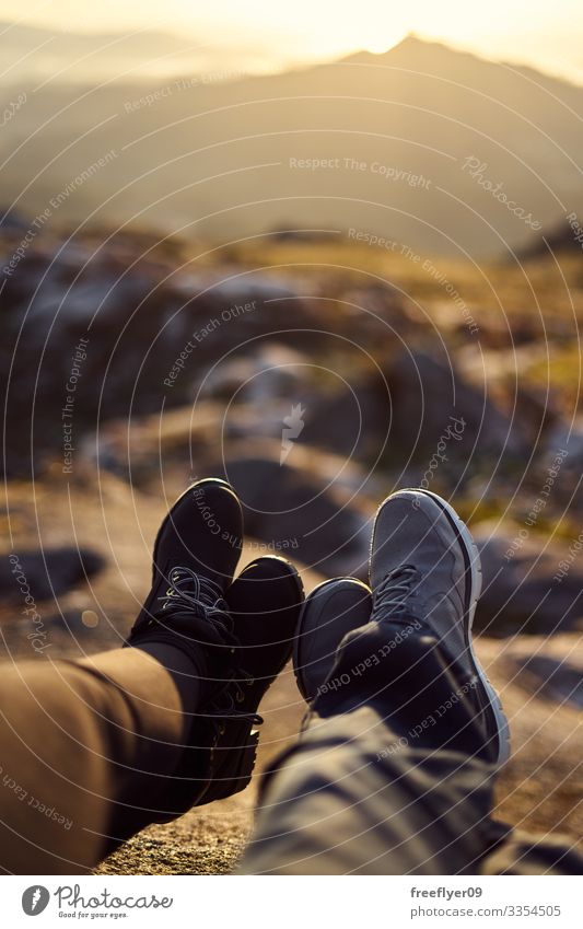 Detail of two pair of feet in front of a defocused landscape at sunset alps idyllic nature mountains morning romantic meadow serene calm vacation stunning