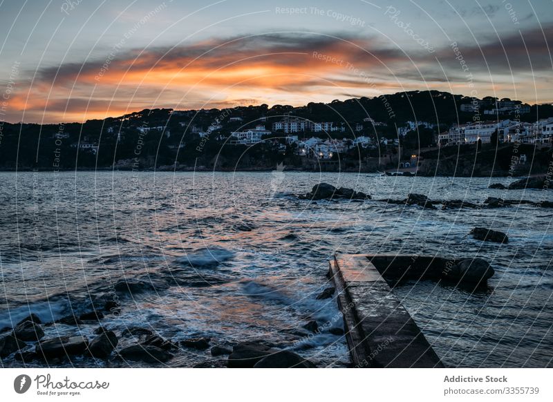 Narrow pier in sunset light surrounded with foamy waves nature landscape water sea sky ocean travel tourism vacation girona catalonia spain orange reflection