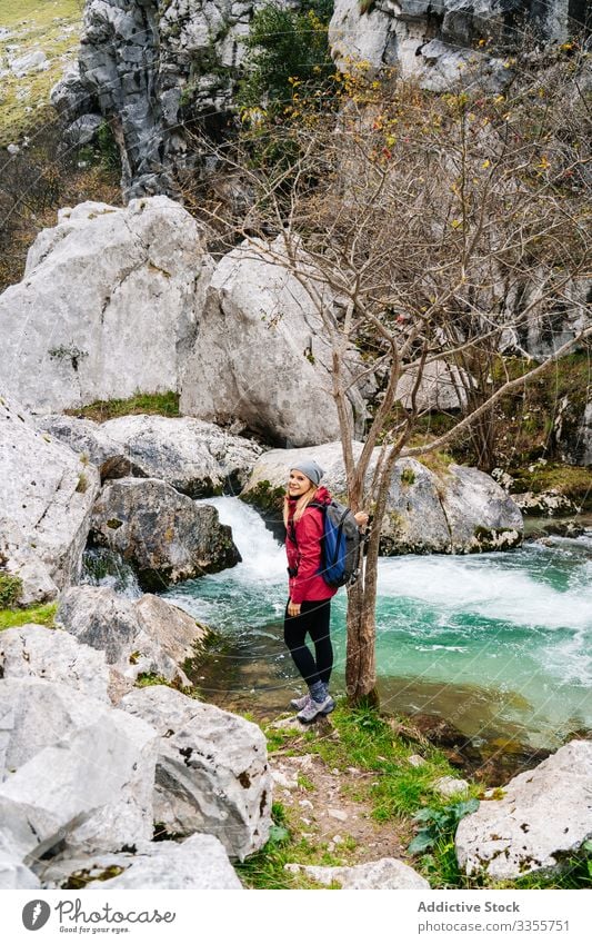 Tourist on stone and enjoying mountain waterfall and lake in mountain woman tourist watching hill travel nature peak landscape tourism adventure dangerous