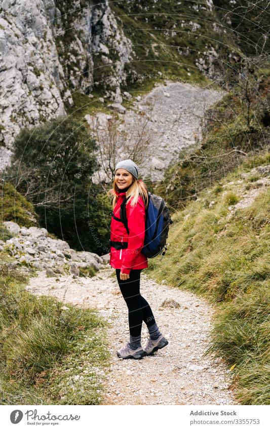 Tourist with backpack walking among path rocks woman tourist peak female mountain hill travel nature trekking landscape sky tourism adventure dangerous extreme