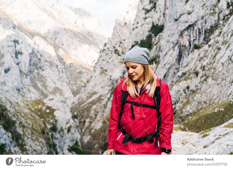 Tourist with backpack walking among high rocks woman tourist peak female mountain hill travel nature trekking landscape sky tourism adventure dangerous extreme