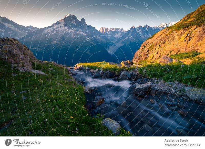 Powerful stream flowing among hills t in snowy mountains in sunlight sky rock river clear nature travel landscape blue tourism natural chamonix mont blanc