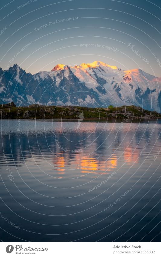 Wavy lake reflecting orange sky and mountains landscape snowy water reflection empty crystal scenic travel sunset tree vacation rock beauty amazing breathtaking