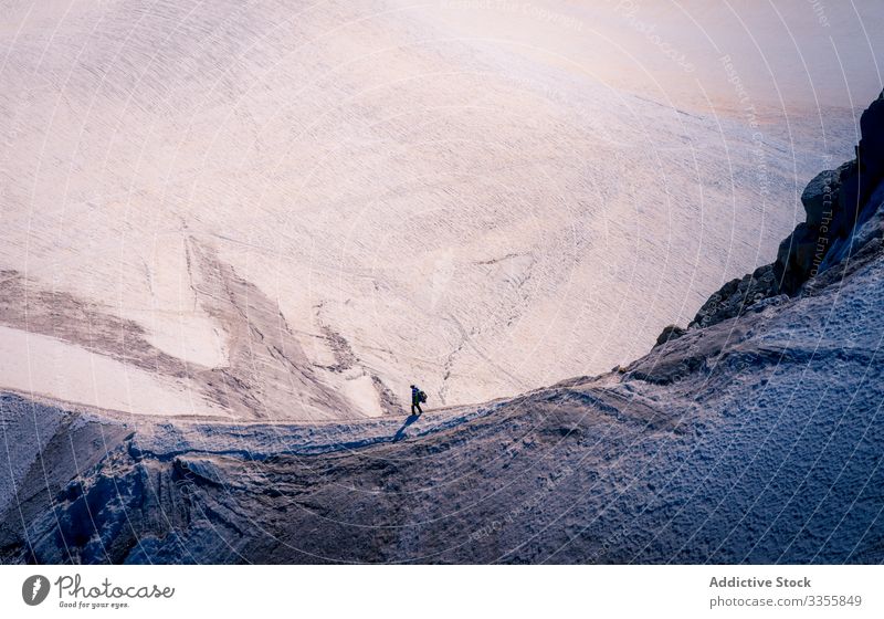 Tourist walking at edge on snowy mountains hiker rock hill peak enjoyment ice hiking scenery rocky nature landscape scenic natural tourist greenery mont-blanc