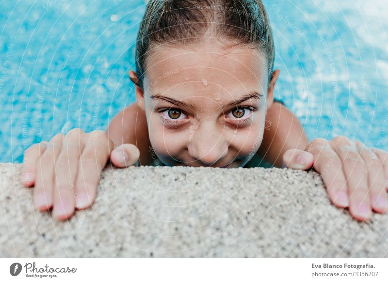 beautiful teenager girl floating in a pool and looking at the camera. Fun and summer lifestyle Action Swimming pool Beauty Photography Exterior shot