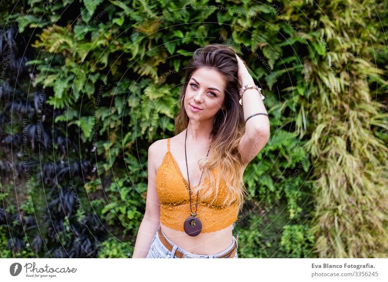 portrait of a young blonde beautiful woman at the street smiling. Green vegetation background. Lifestyle outdoors. Summertime Modern Hip & trendy Eroticism