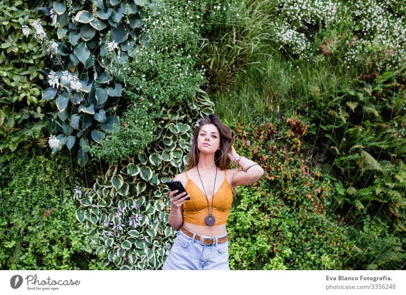 young blonde beautiful woman at the street using mobile phone and smiling. Lifestyle outdoors. Summertime, Green background Smart Town Happy Human being Smiling