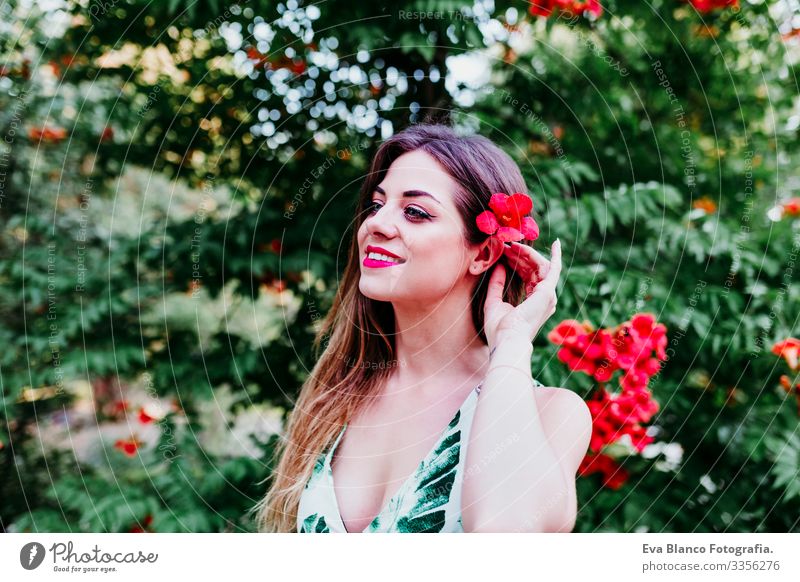 portrait of beautiful blonde young woman smiling at sunset. Playing with red flowers. Happiness and lifestyle concept outdoors Caucasian toothy Cute Happy Girl