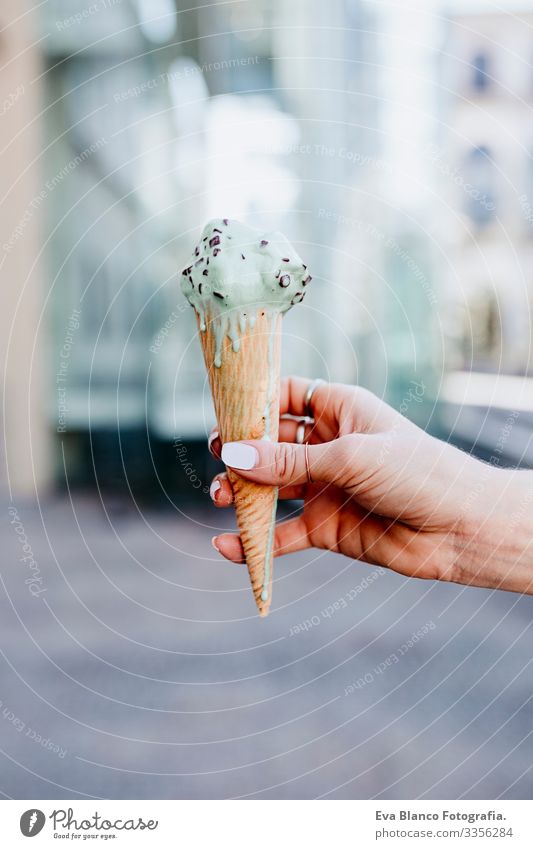 woman hand holding a mint ice cream at the city street on a sunny day. Urban and summer lifestyle Day Street Beautiful Woman Sunbeam Cheerful Model Expression