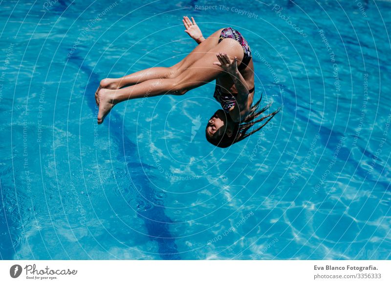 funny kid girl jumping into the pool, summer time Lifestyle Swimming pool Vacation & Travel Sun Summer healthy Cute Smiling Child Blue Caucasian Playful