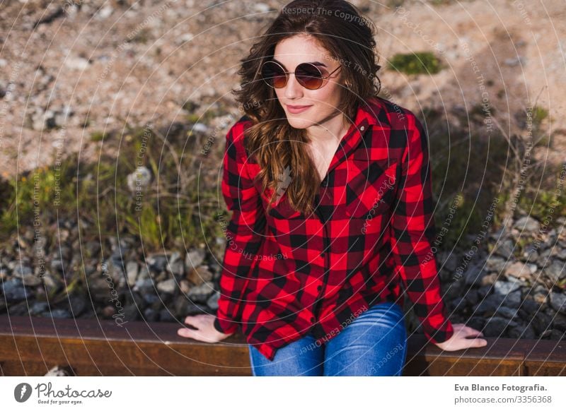 young beautiful woman wearing casual clothes, sitting on the railway and smiling. Outdoors lifestyle. Travel concept. City Feminine Fashion Attractive