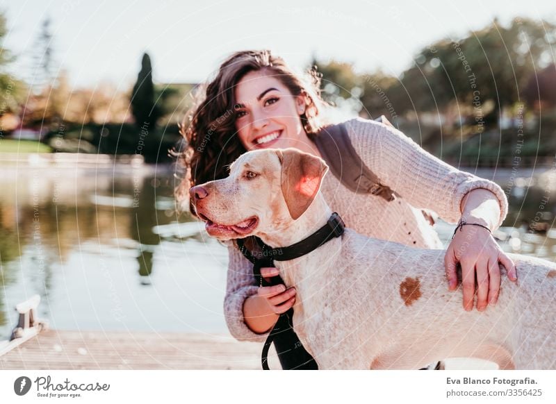 young woman and her dog outdoors in a park with a lake. sunny day, autumn season Woman Dog Park Youth (Young adults) Exterior shot Love Pet owner Sunbeam