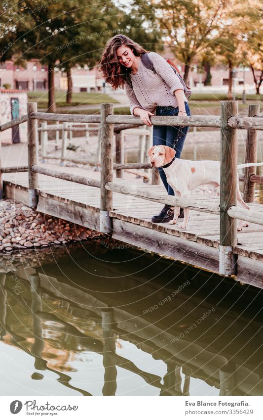 young woman and her dog outdoors in a park with a lake. sunny day, autumn season Portrait photograph Woman Dog Park Youth (Young adults) Exterior shot Love Pet