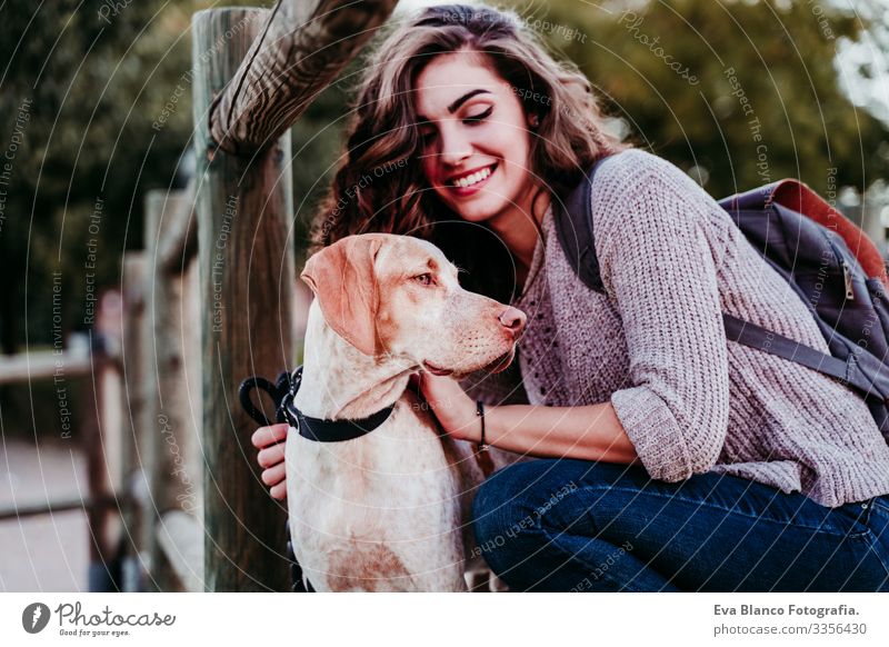 young woman and her dog outdoors in a park with a lake. sunny day, autumn season Portrait photograph Woman Dog Park Youth (Young adults) Exterior shot Love Pet