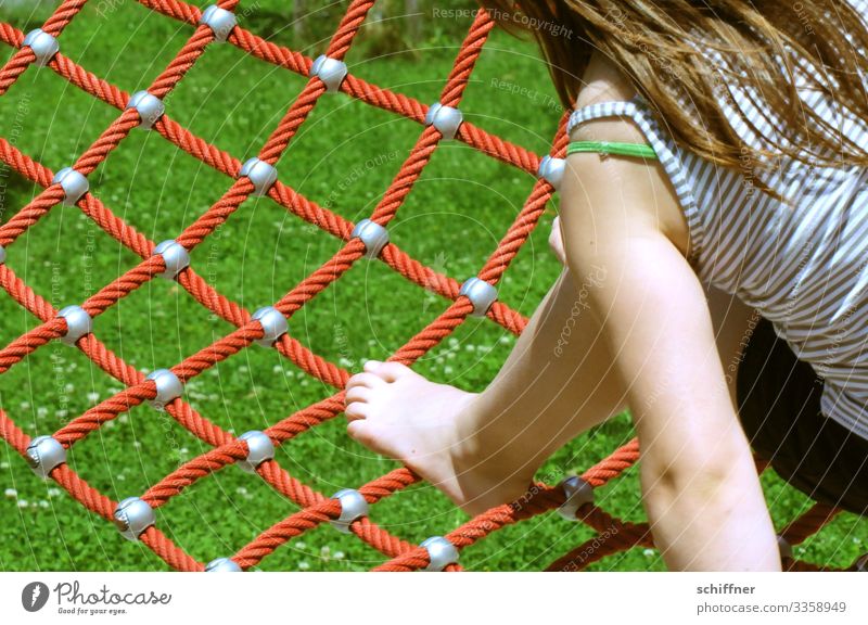 Girl playing on a playground Playing playing children children's playground Playground from behind balance Net Safety