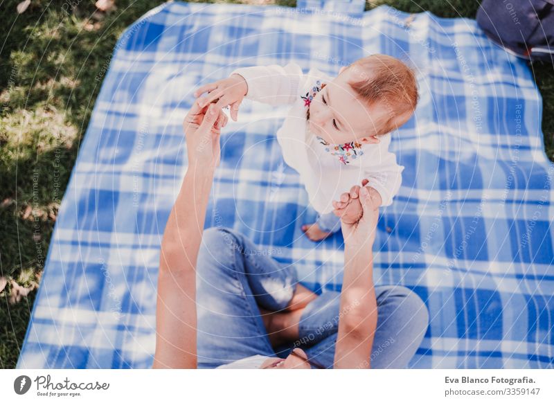 young mother playing with baby girl outdoors in a park, happy family concept. love mother daughter Child Parenting Girl Joy Sunbeam Parents Mother Spring Baby