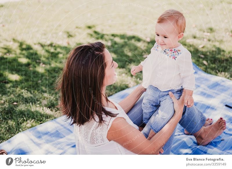 young mother playing with baby girl outdoors in a park, happy family concept. love mother daughter Child Parenting Girl Joy Sunbeam Parents Mother Spring Baby