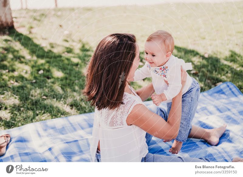 young mother playing with baby girl outdoors in a park, happy family concept. love mother daughter Child Parenting Girl Joy Sunbeam Parents Mother Spring Baby