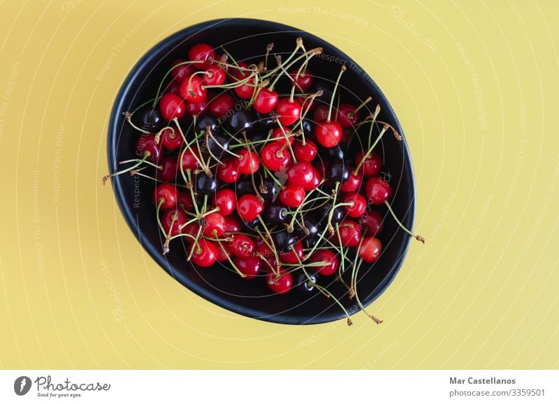 Black ceramic bowl with wild cherries on yellow background. Food Fruit Dessert Nutrition Vegetarian diet Diet Bowl Healthy Eating Wellness Summer Nature