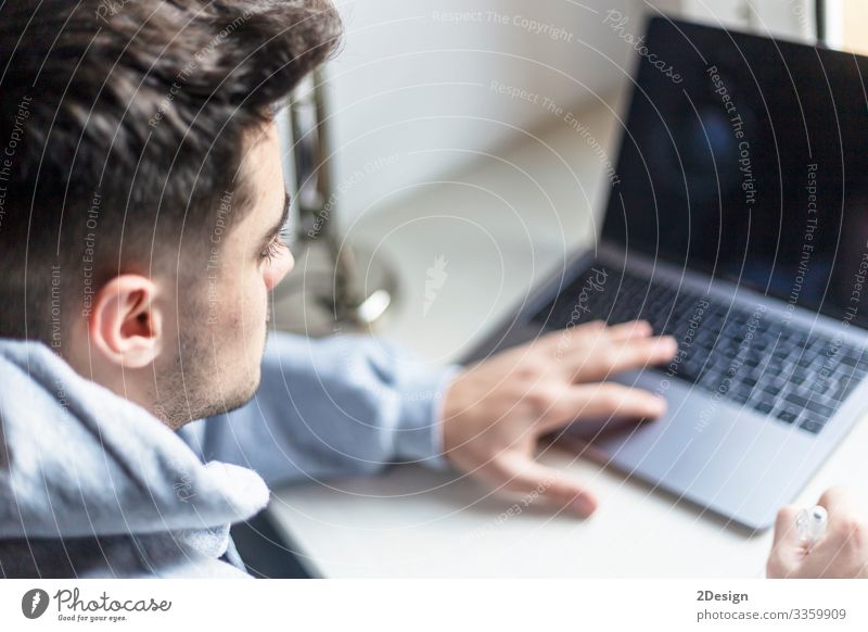 Rear view of a young man working with laptop on desktop Decoration Desk Table Work and employment Workplace Office Business Computer Notebook Screen Software