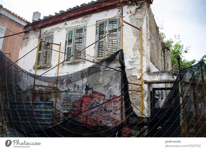 Demolition house secured with net condemned house safety net Protection Sky Facade Scaffold Architecture Collateralization Support Ravages of time Change