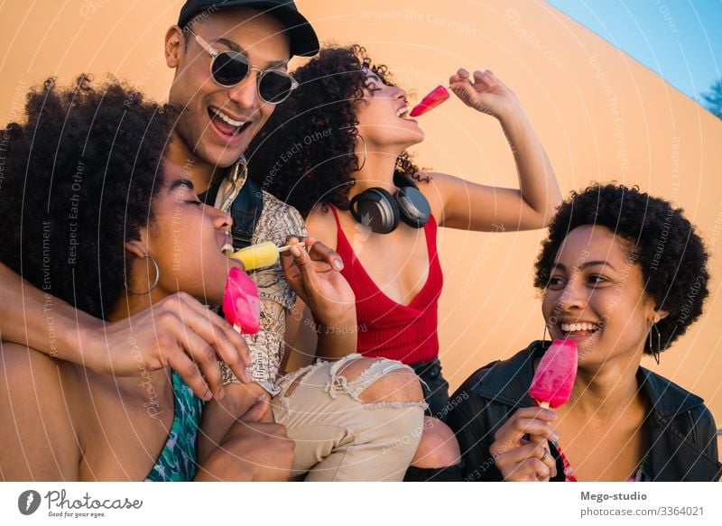 Multi-ethnic group of friends enjoying summertime while eating ice cream. multiethnic friendship young people dessert diversity diverse pleasure man woman