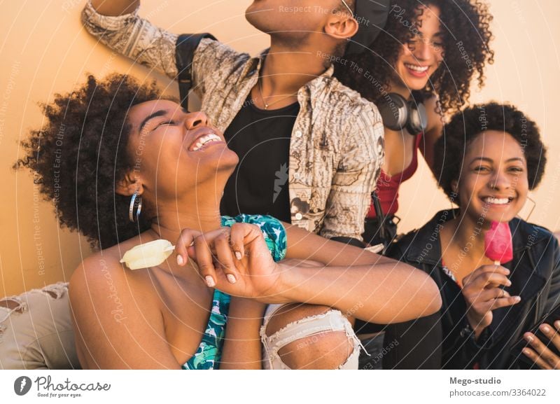 Multi-ethnic group of friends enjoying summertime while eating ice cream. multiethnic friendship young people dessert diversity diverse pleasure man woman