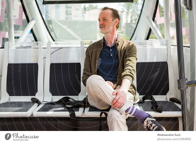 Interior of automated remotely operated bus in Helsinki. Unmanned public transport test on street. Passenger sitting on seat, waiting on bus stop. autonomous