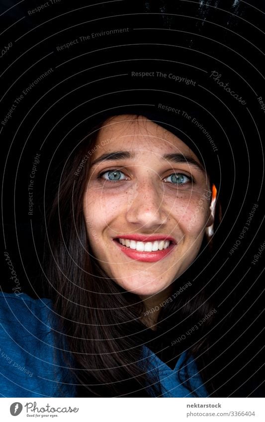 Face of Middle Eastern Woman with Light Colored Eyes in Large Black Hat female girl beauty shot hat smile portrait light colored eyes tanned skin