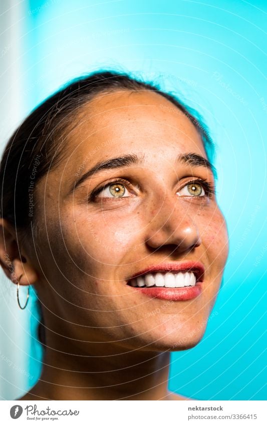 Face of Young Indian Woman Smiling on Blue Background hazel eyes female girl smile toothy smile woman young adult female beauty beautiful woman natural beauty