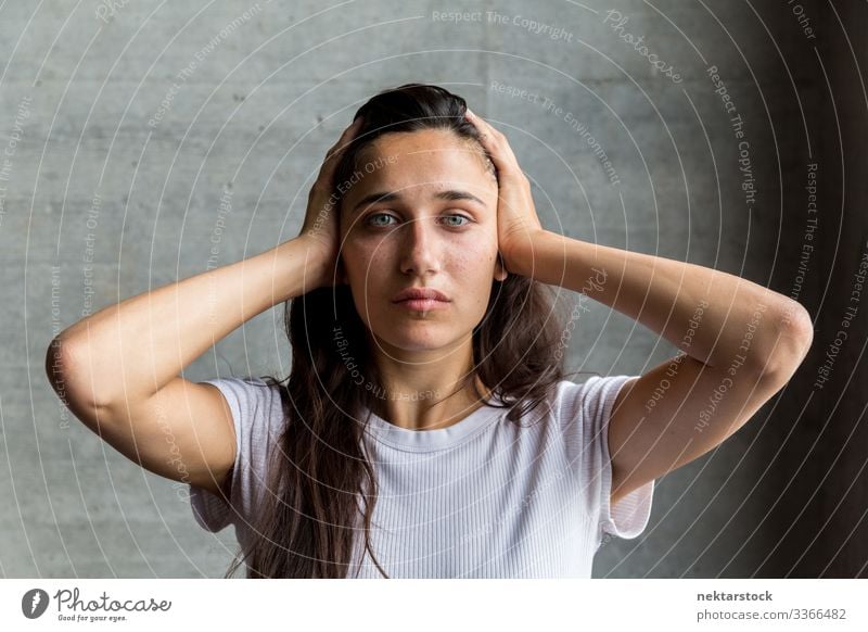 Young Woman with Hands on Temples female girl woman young adult portrait hands on head serious looking at camera medium shot beautiful woman natural beauty