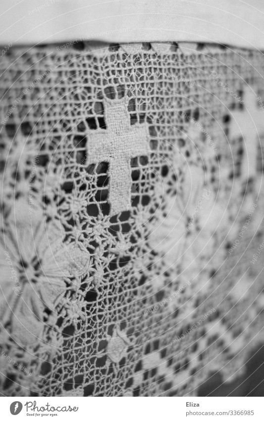 A white crocheted blanket with flowers and crucifix/cross ornaments and patterns in the church Crocheted decorative blanket doily Pattern Ornament Church