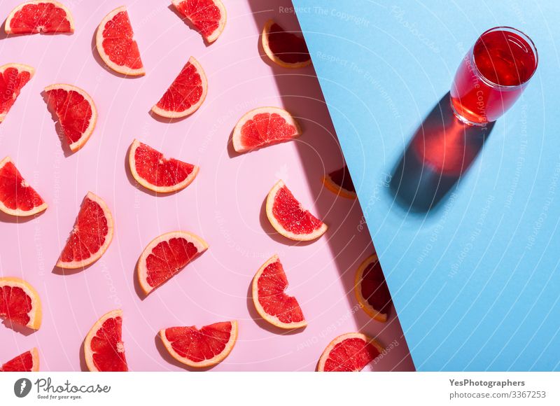 Grapefruit drink on blue background. Fresh grapefruit slices Beverage Cold drink Lemonade bicolor Blue background Citrus fruits colorful detox beverage duotone