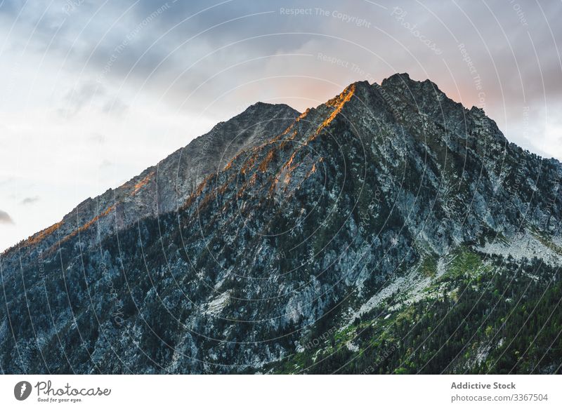 Rocky peak against cloudy sky mountain rock landscape nature high wild ridge range scenic travel tourism world wilderness sunlight vacation day adventure scene