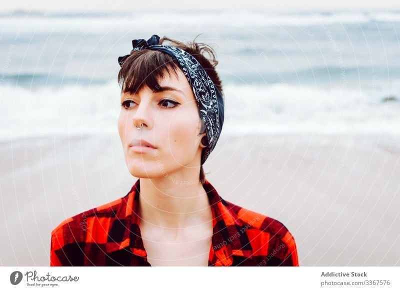 Woman smoking cigarette on beach woman smoke casual sea serious concept stormy light sand young female ocean water red nature travel coast seaside environment