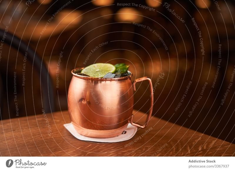 Moscow Mule cocktail in copper mug alcohol classic moscow mule vodka whiskey drink beverage lime beer ginger bar yellow counter cold luxury aperitif traditional