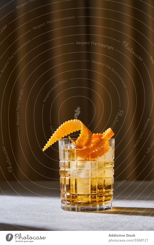 Old fashioned cocktail on table in pub old fashioned bar alcohol whiskey peel orange drink glass cup beverage ice cold cool classic liquor citrus refreshment