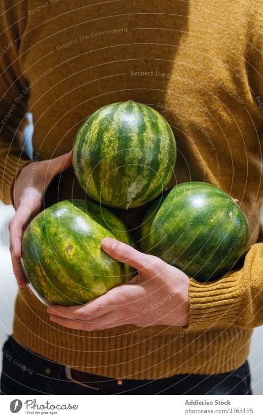 Crop man with small watermelons summer fruit market carry ripe sunny daytime male fresh sweet food vitamin vegetarian vegan diet organic natural treat grocery