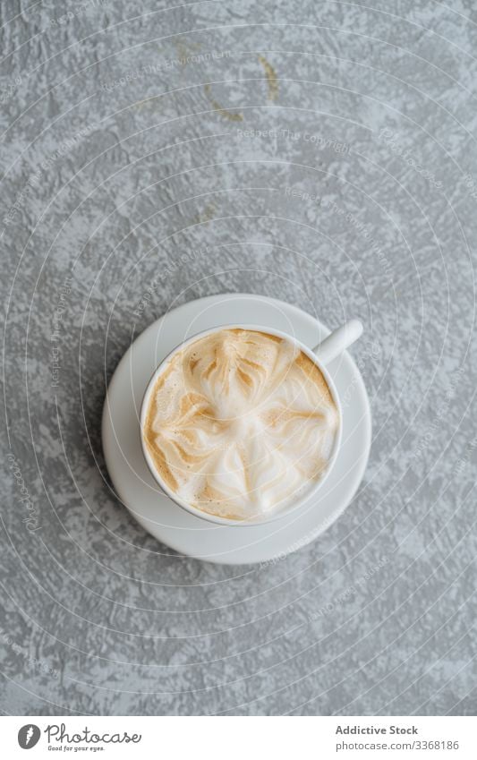 Cup of cappuccino on grey textured background coffee cup art latte drink hot beverage saucer froth foam breakfast cafe morning caffeine aroma flavor gourmet