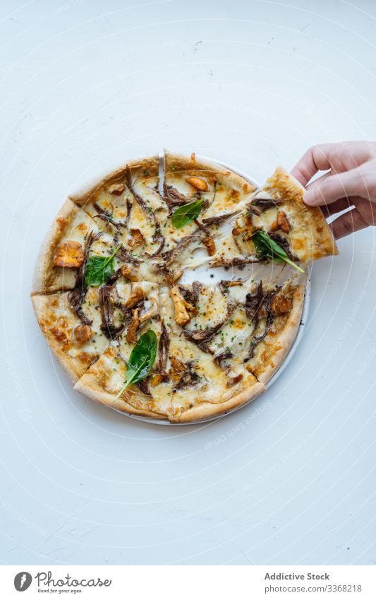 Crop person taking piece of seafood pizza slice cheese basil mushroom dish tasty portion try warm hot herb ingredient recipe baked roasted fried prepared fresh