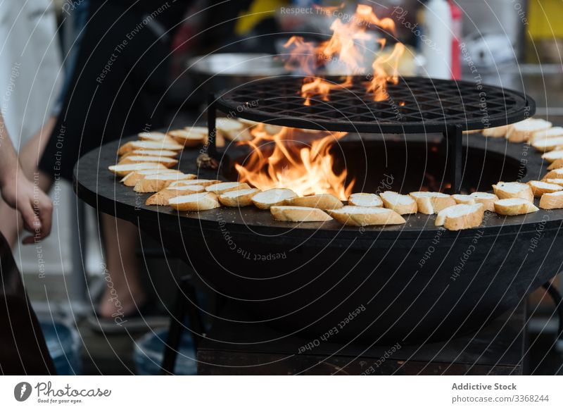 Cooking traditional street paella under awning cook rice preparation food marketplace dish hot oil fire oven lunch eatery party delicious tasty cooked meal rain