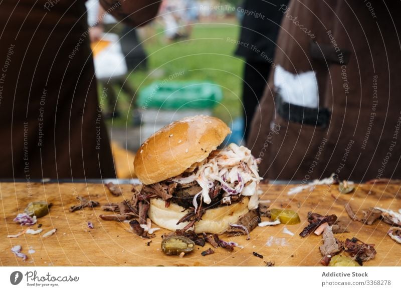 Burger of cucumber with squid and beef burger table meat dish cole slaw onion marketplace bun food mixed fast food meal cookery fresh seafood grilled fried