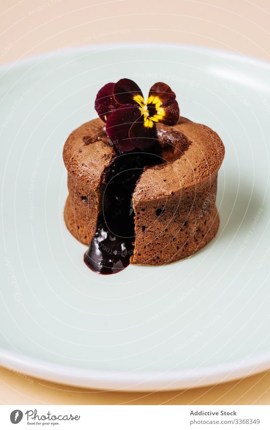 Chocolate muffin with chocolate filling dessert fruit flower plate cafe sweet passionfruit food pastry cut liquid sauce tasty cuisine dish delicious yummy