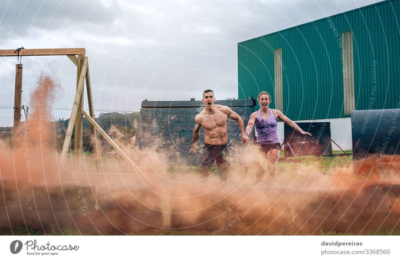 Couple jumping tires at finish line of obstacle course Happy Sports Success Human being Woman Adults Man Jump Authentic Energy Competition Teamwork athlete