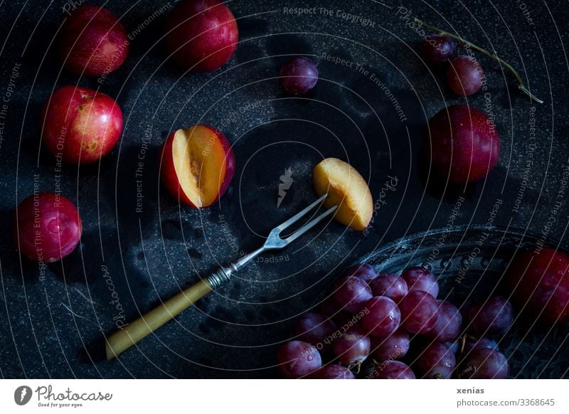 Nectarine with fork and red grapes on black background Bunch of grapes fruit Nutrition Organic produce Vegetarian diet Diet Fork Healthy Eating Food